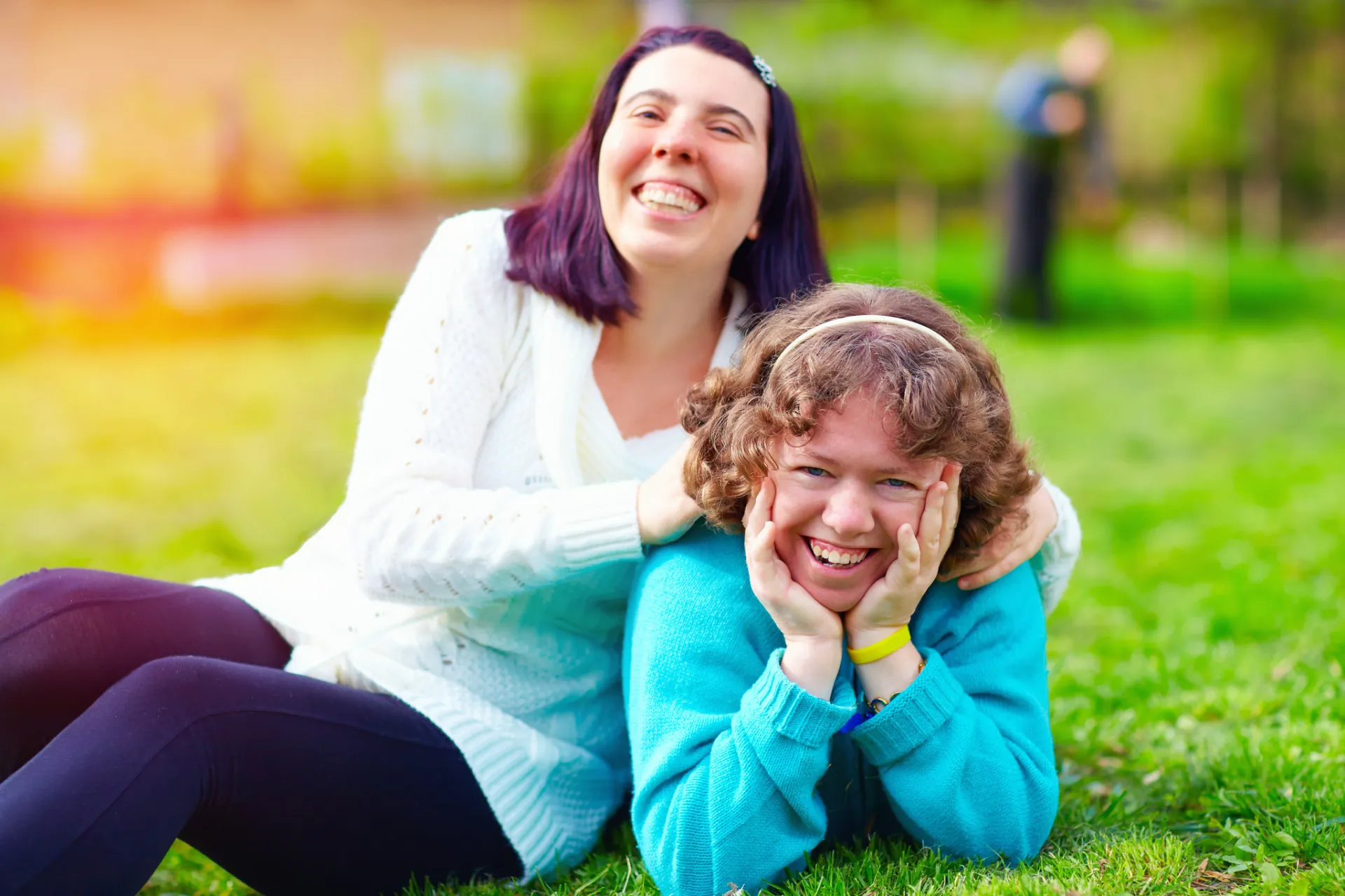 Two women smiling posing in the park
